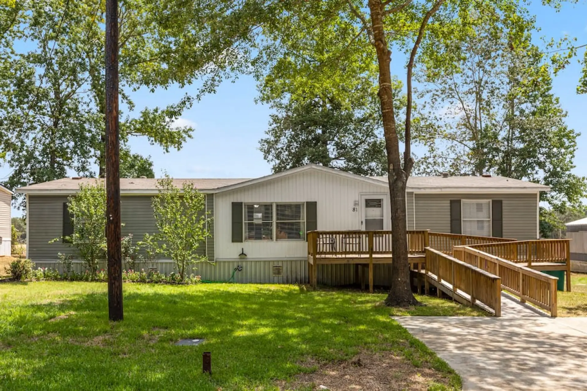 Accessible front entrance with wheelchair ramp, front deck, and parking for two cars
