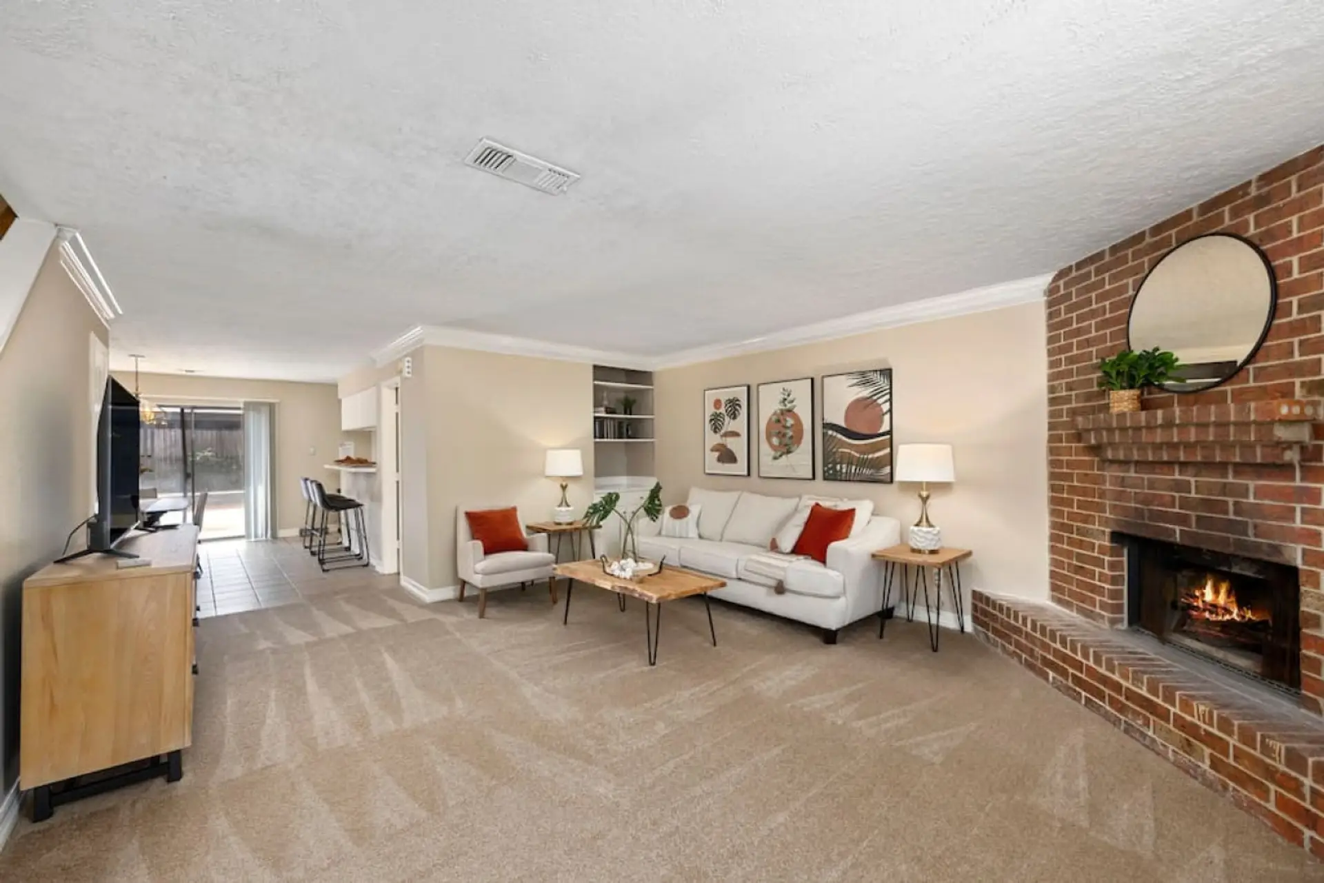 Spacious living room with 55″ Smart TV, queen sleeper sofa, and open layout to kitchen and dining