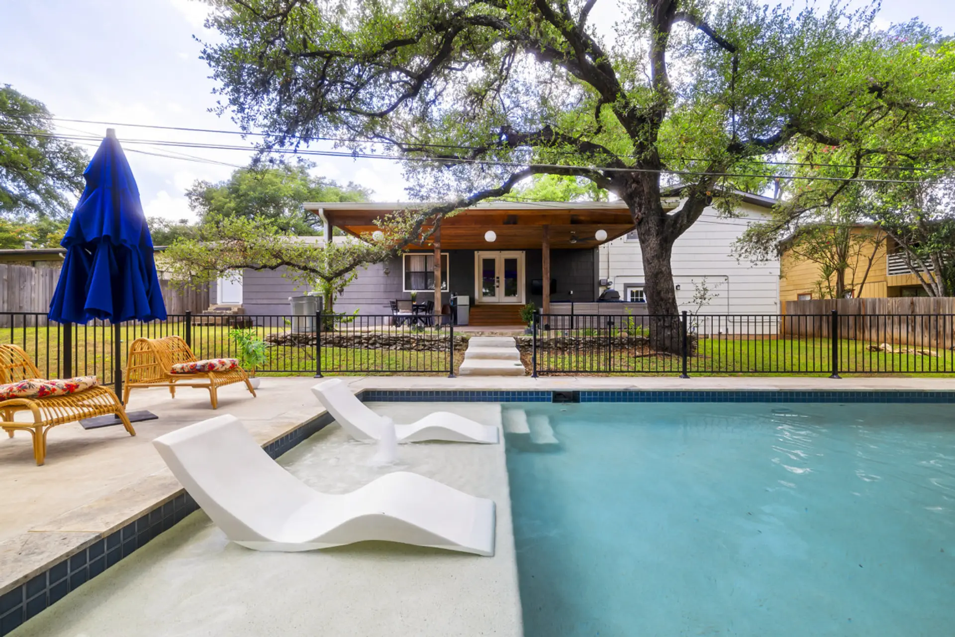 Private swimming pool with in-water loungers on a spacious fenced yard — perfect for sunny San Marcos days