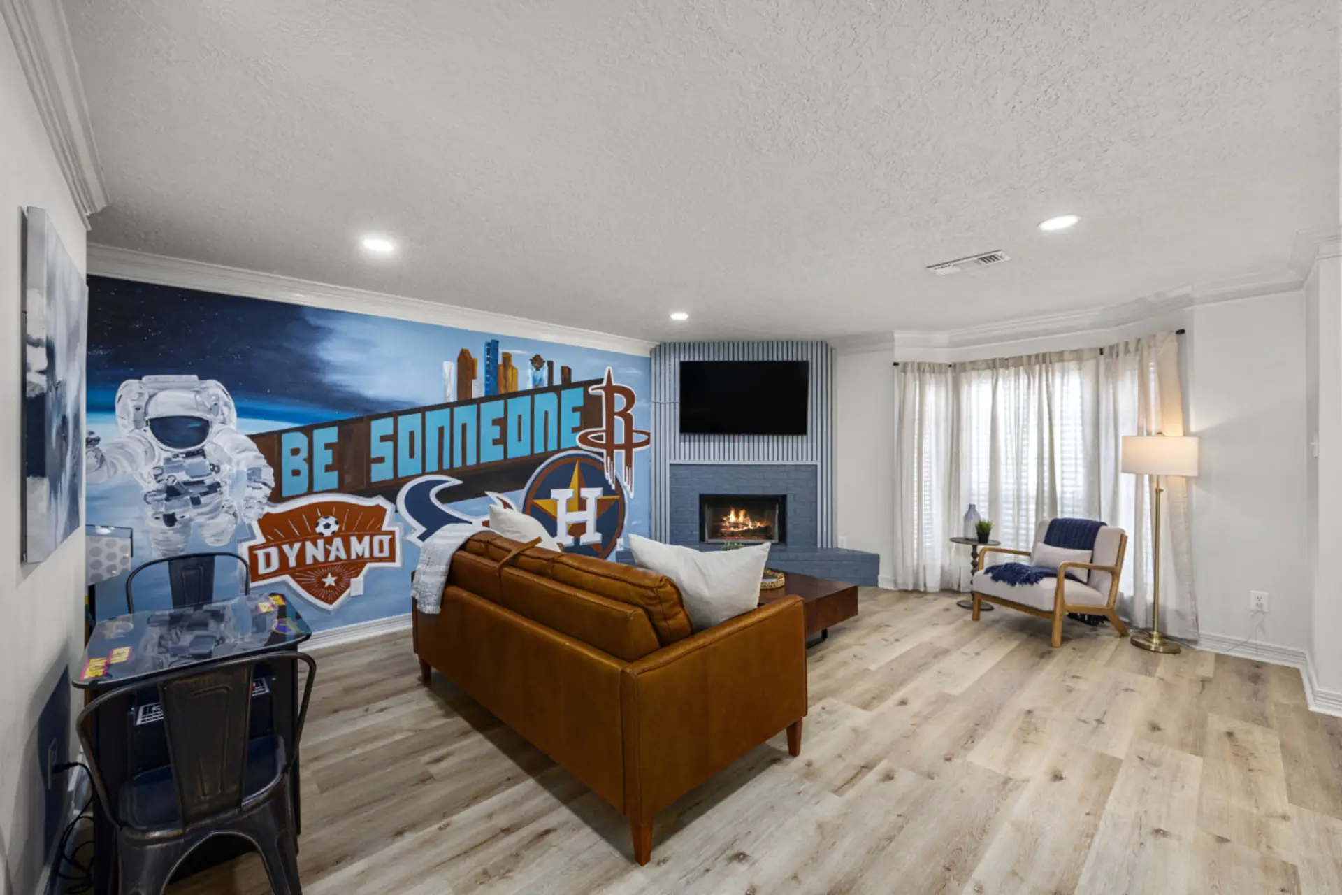 The spacious living room has a Houston Inspired mural, retro arcade game, pull out queen sofa, and a smart TV