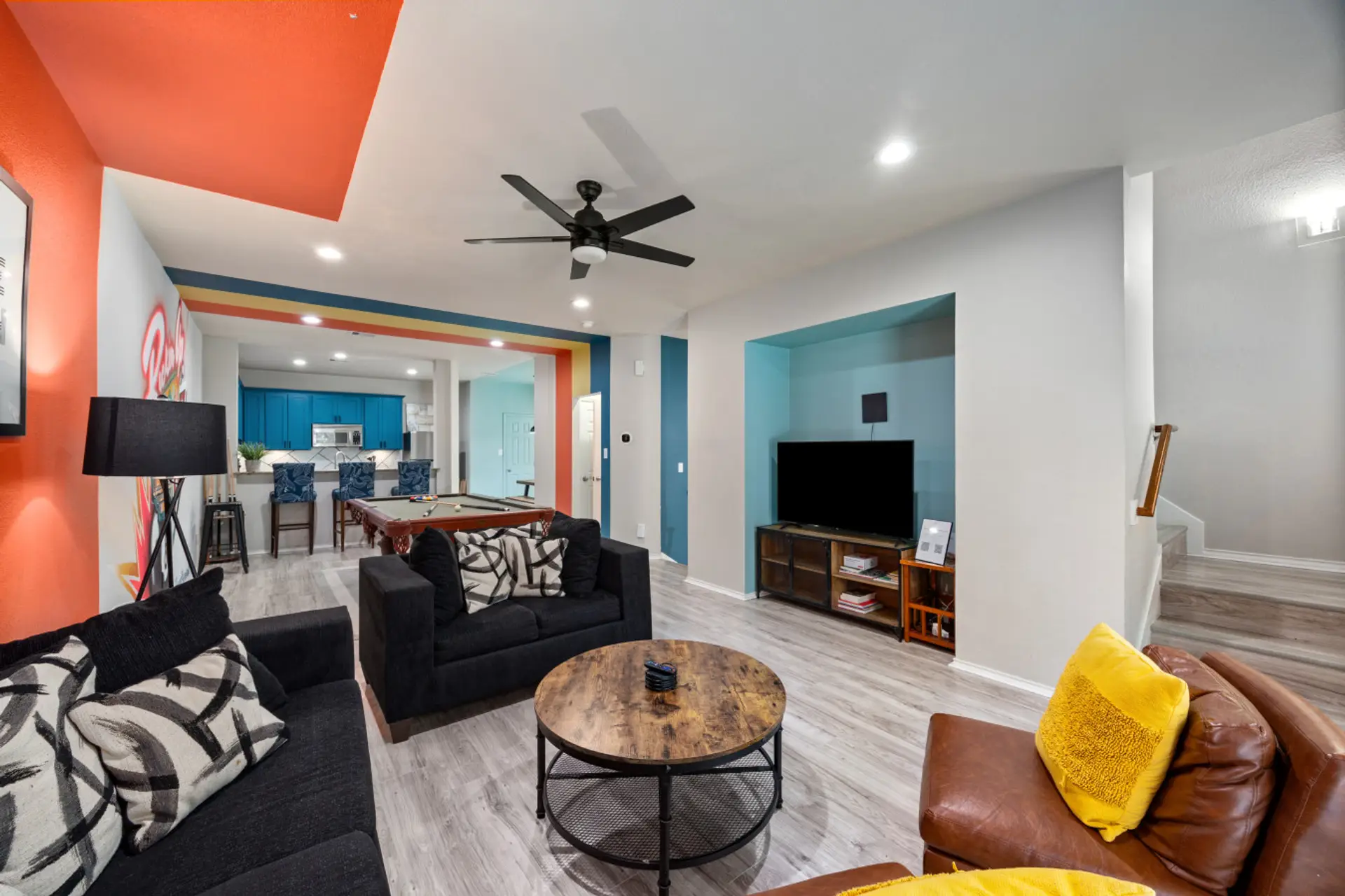 Spacious second-floor living area with Smart TV, comfortable seating, and open layout connecting to the kitchen and game space—perfect for relaxing between EaDo adventures.