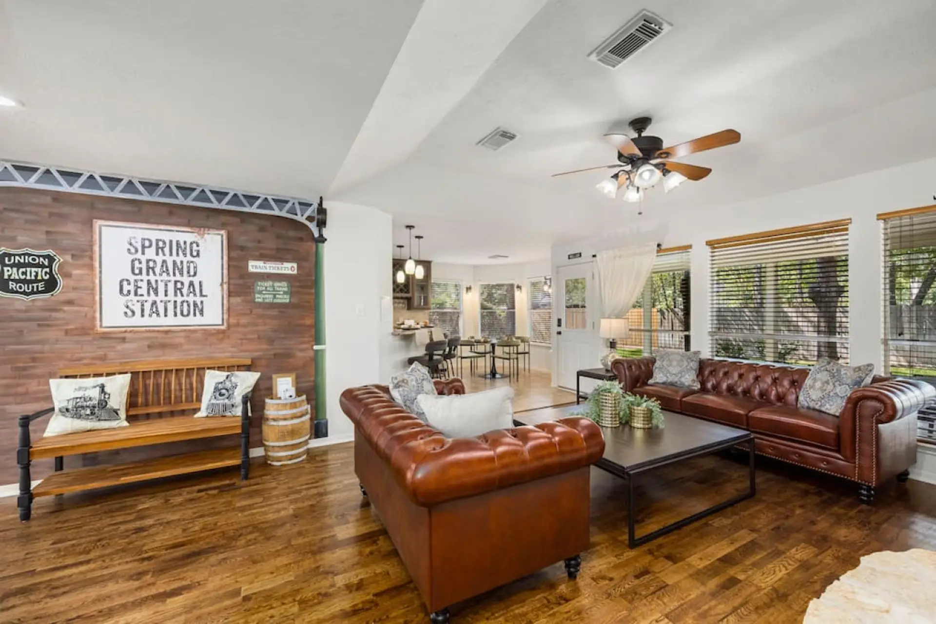 Spacious train-themed living room with leather sofas, 65” Smart TV, and open layout — ideal for gathering after pool time