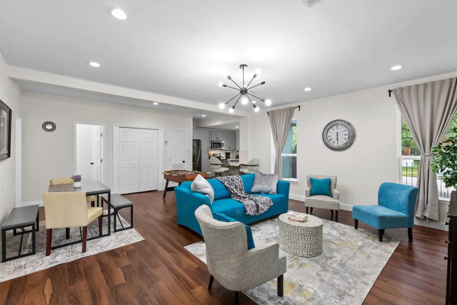 Bright open-concept living room with plush seating, dining area, and full kitchen — perfect for relaxing, working, or gathering after a day in the Med Center or Downtown