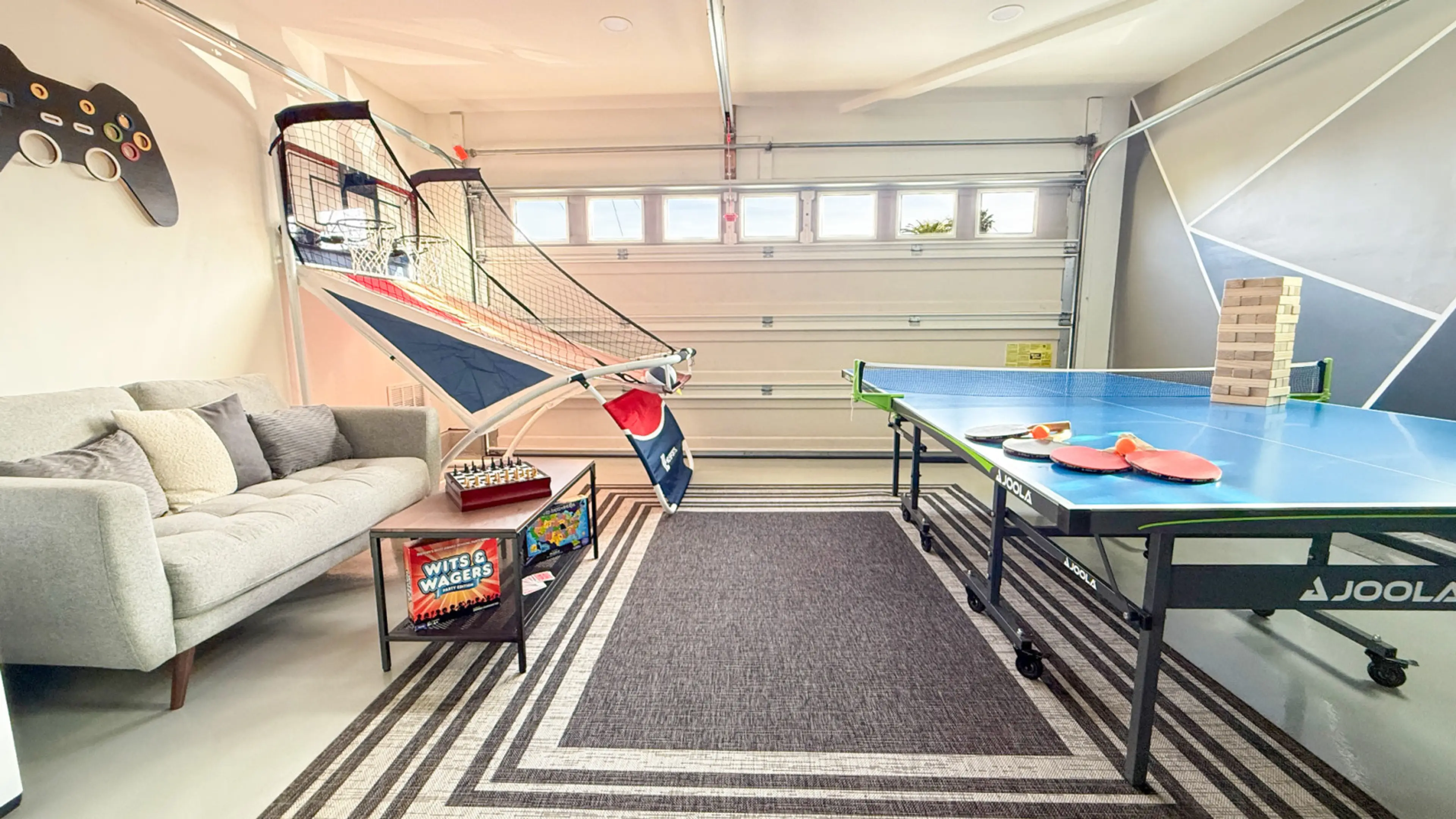 Game room equipped with ping-pong table, multiple games, and Smart TV.