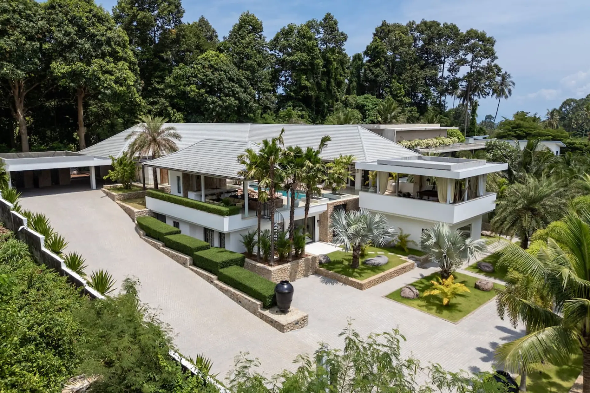 Elegant villa exterior with traditional Thai-style architecture and manicured gardens