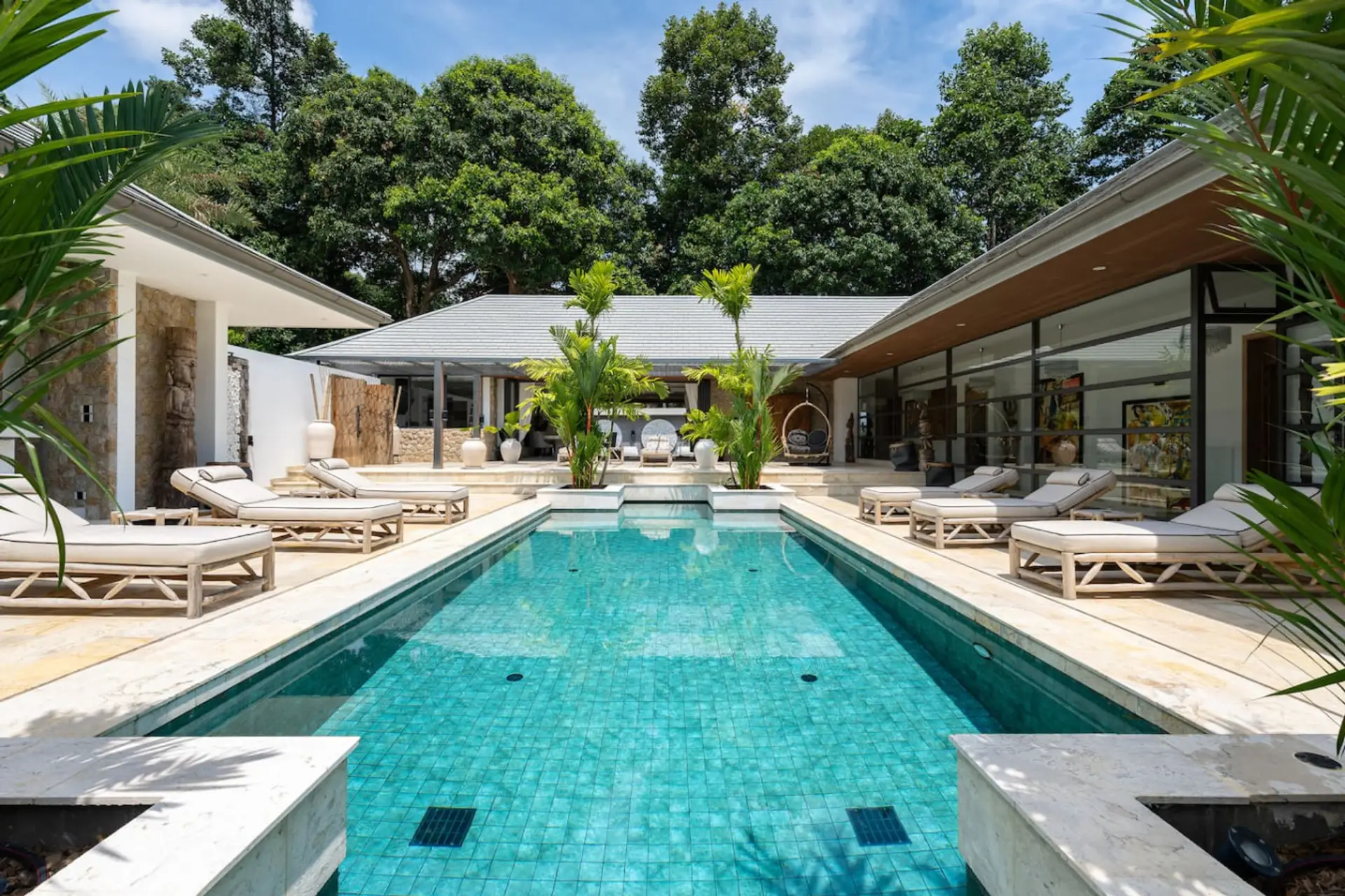 Sparkling private pool surrounded by lush tropical gardens and villa pavilions