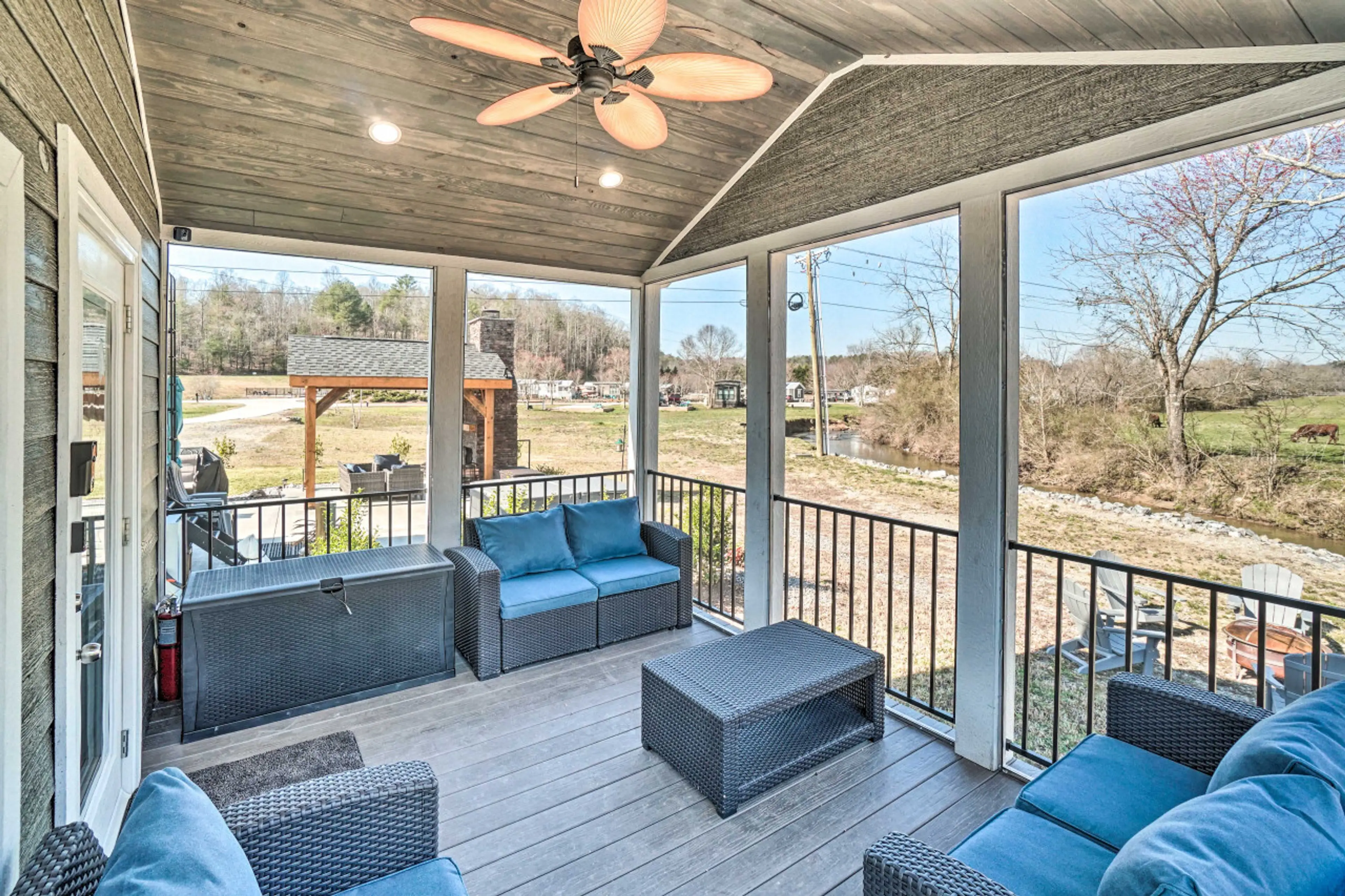 Relax on the spacious screened porch with comfortable seating, a ceiling fan, and beautiful views of the countryside—a perfect spot to unwind in any weather