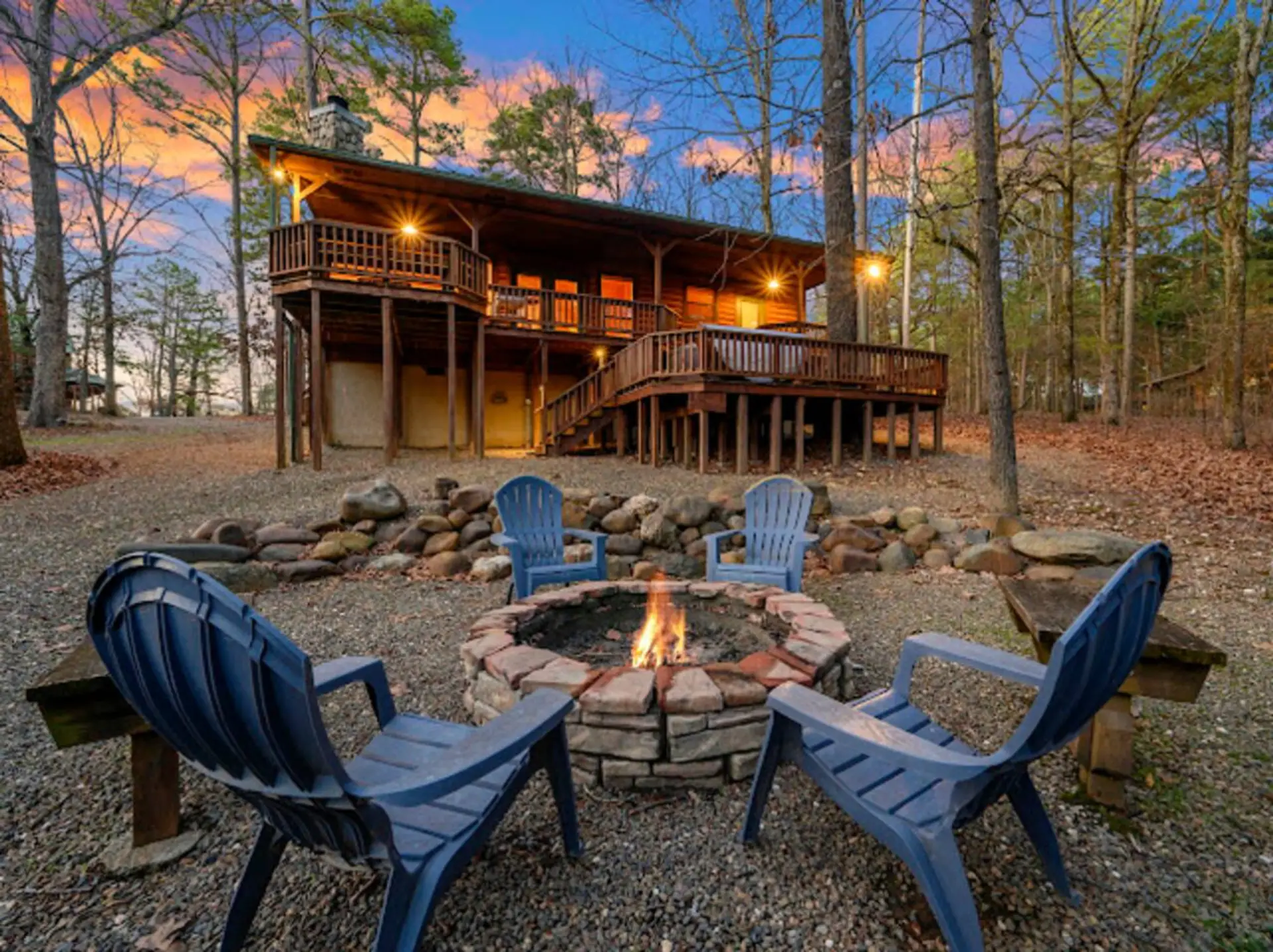 Gather around the fire pit with those comfy Adirondack chairs while the cabin glows behind you in the woods.