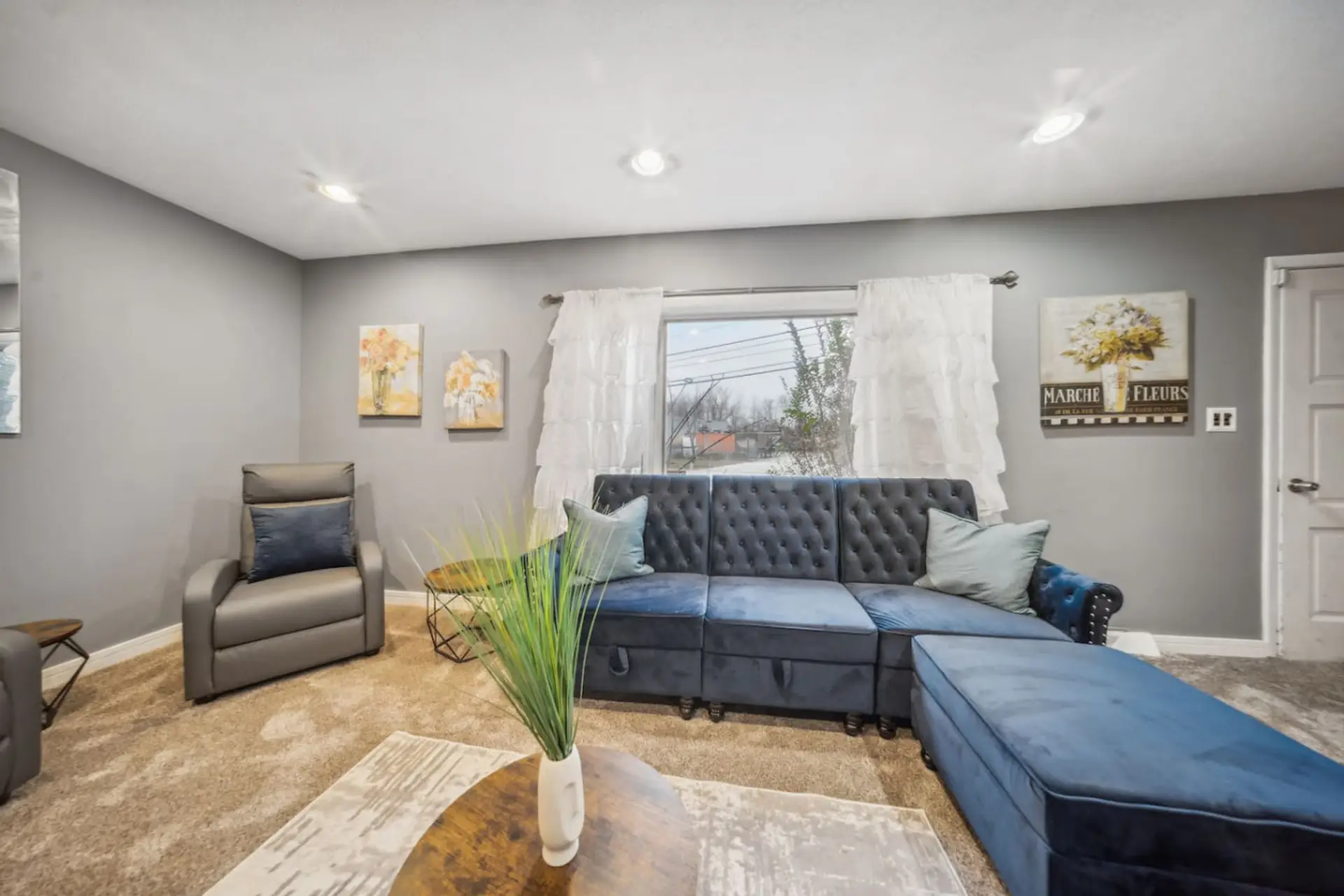 Settle into this elegant tufted blue sectional, offering ample space and comfort for the whole group to gather and relax.