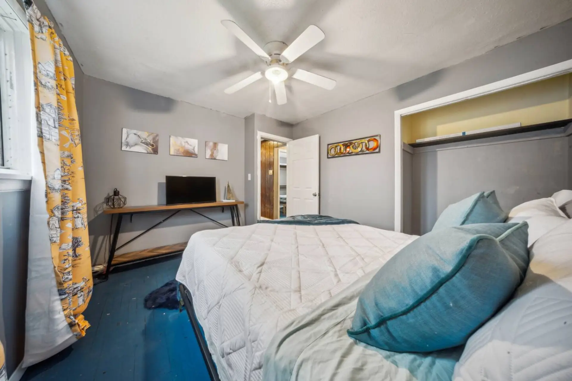 Brighten your stay in this cheerful bedroom, complete with a cozy queen-sized bed, vibrant yellow accents, and a private TV for your entertainment.