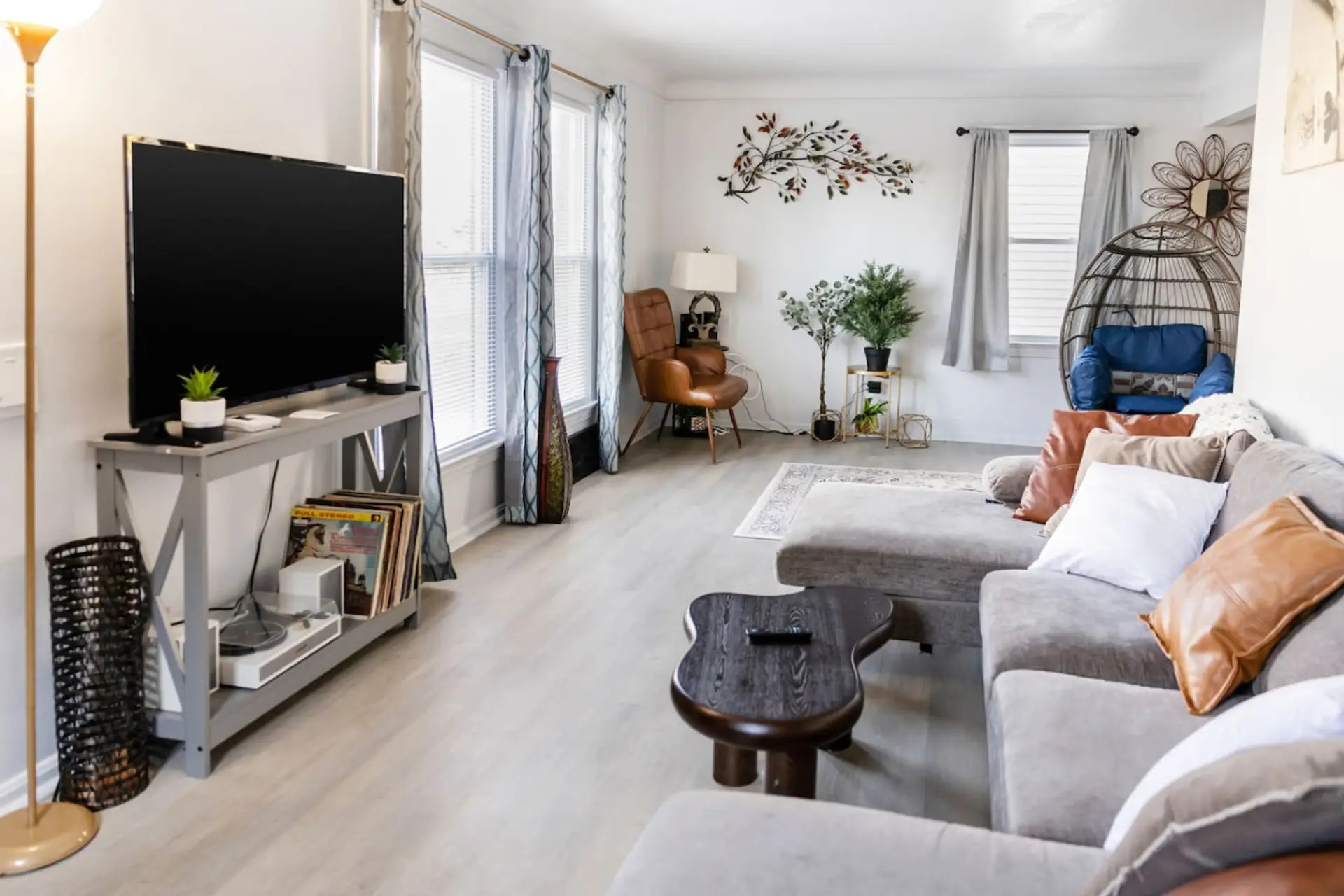 Relax and unwind in this inviting living room, featuring a plush gray sectional, modern minimalist decor, and a large flat-screen TV—perfect for cozy movie nights or gathering with family and friends.