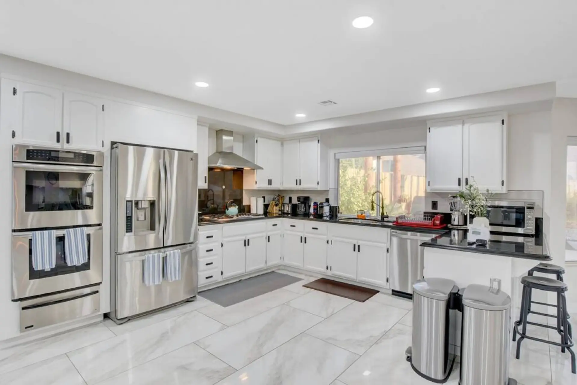 Fully Equipped Kitchen with view to the backyard, pool, Kitchen is located in the center of the house
