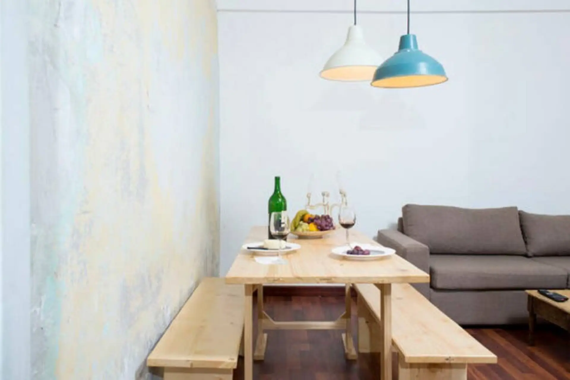 Enjoy meals together at the wooden dining table under charming pendant lights.