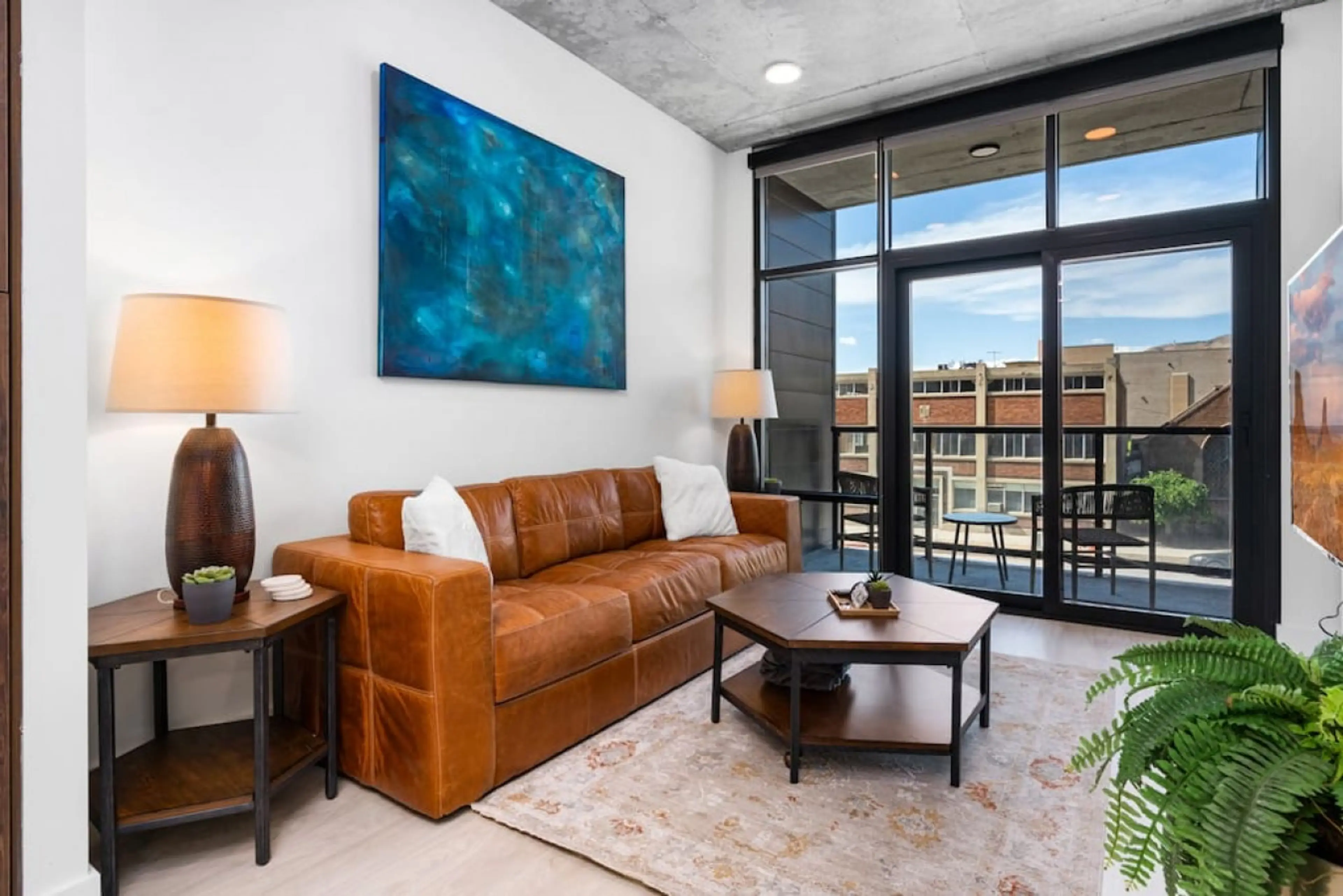 Beautifully designed living room. 65" TV, leather sofa and amazing views of mountains and city skyline.