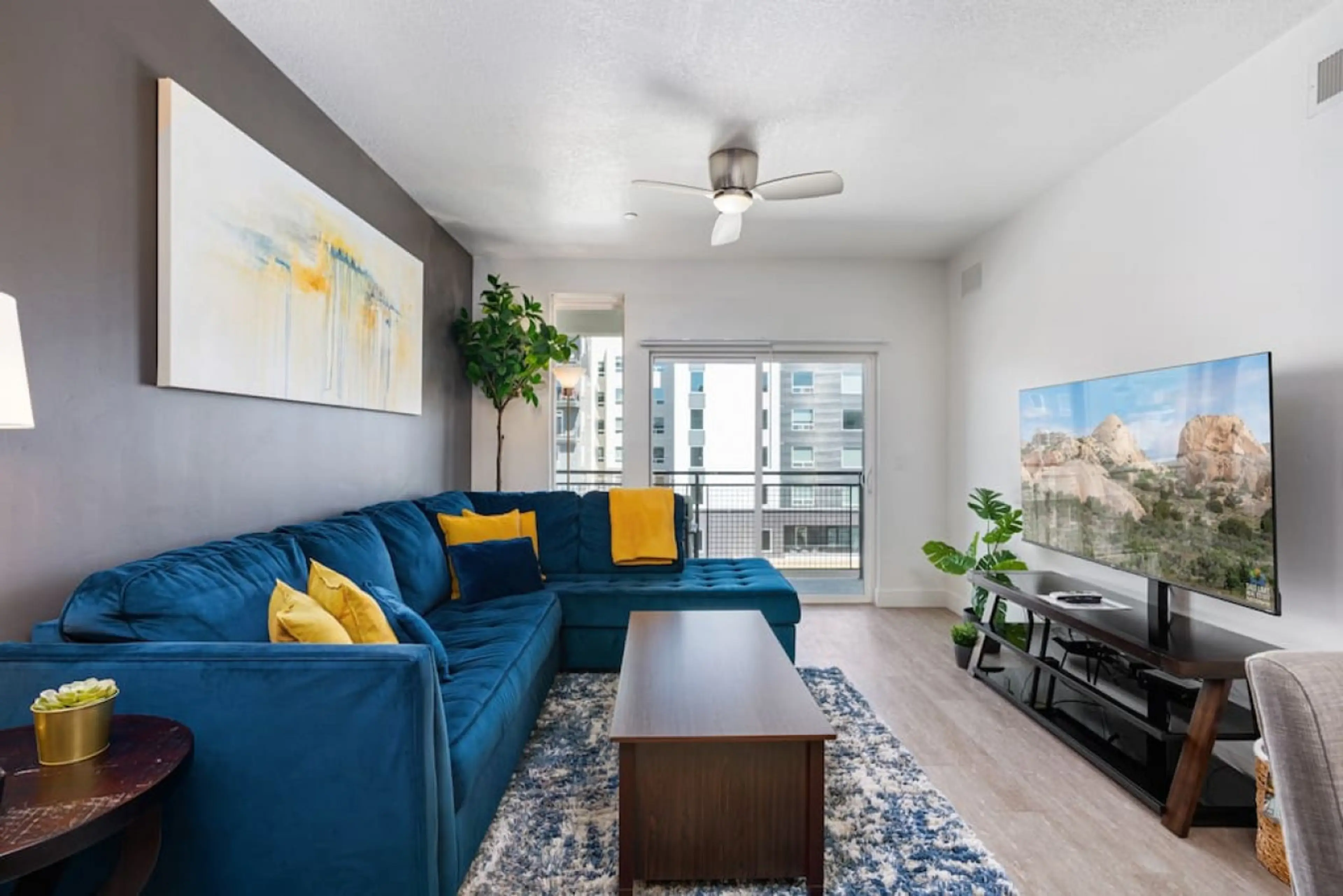 Beautifully designed living room. 65" Roku TV, colorful sectional sofa and amazing views of mountains and city skyline.