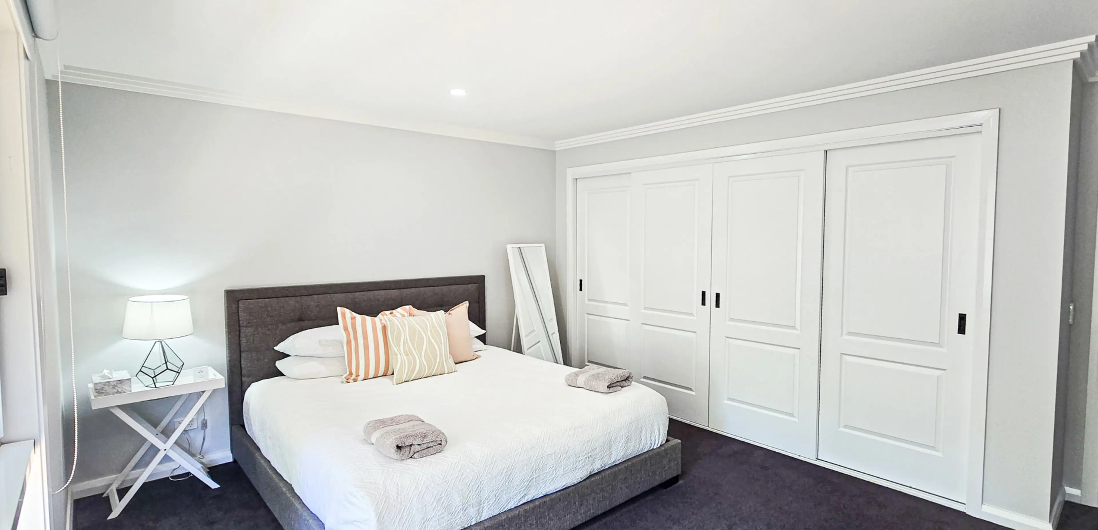 The master bedroom features a king bed, premium linens, and a mounted TV for relaxed nights in.
