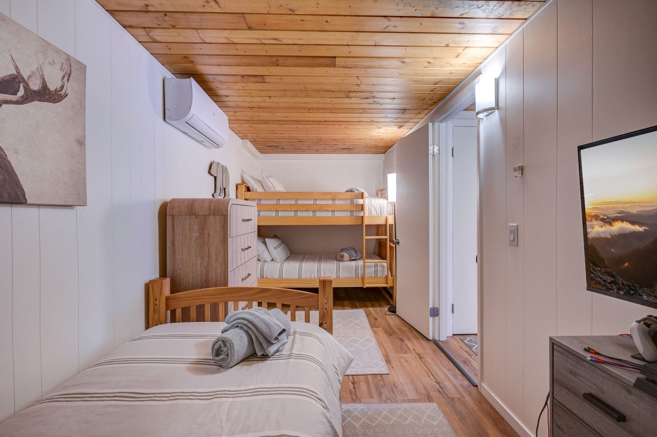 A bunk bed and a twin bed.  This bedroom also includes an AC and a TV with a gaming console that kids just love to play