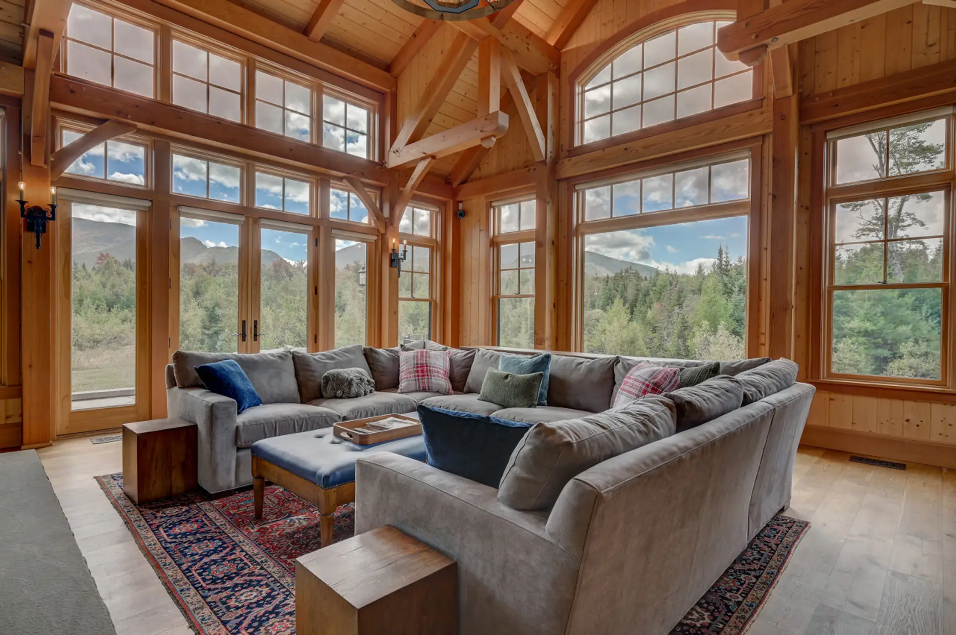 Stunning great room with a spacious sectional, large fireplace, and breathtaking panoramic views of Cannon Mountain. Perfect for relaxing with family or watching TV by the fire.