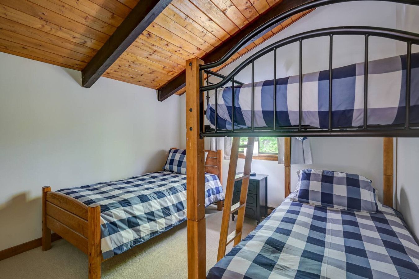 Twin over twin bunk bed, plus another twin bed, located on the upper level