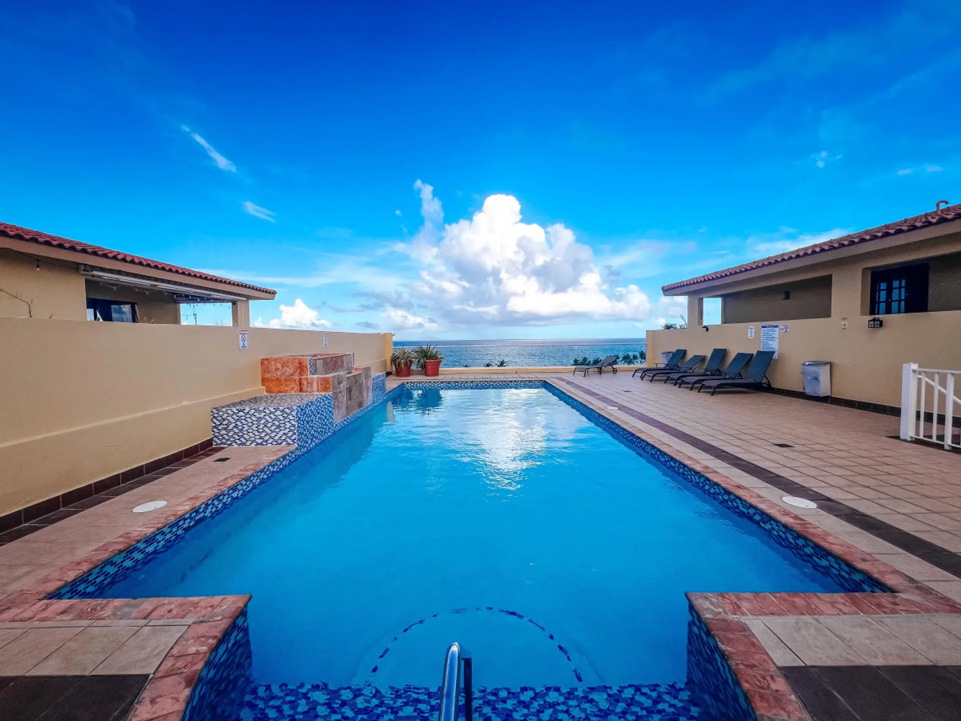 This serene pool area features ambient lighting, creating a beautiful, inviting atmosphere for both day and night swims.