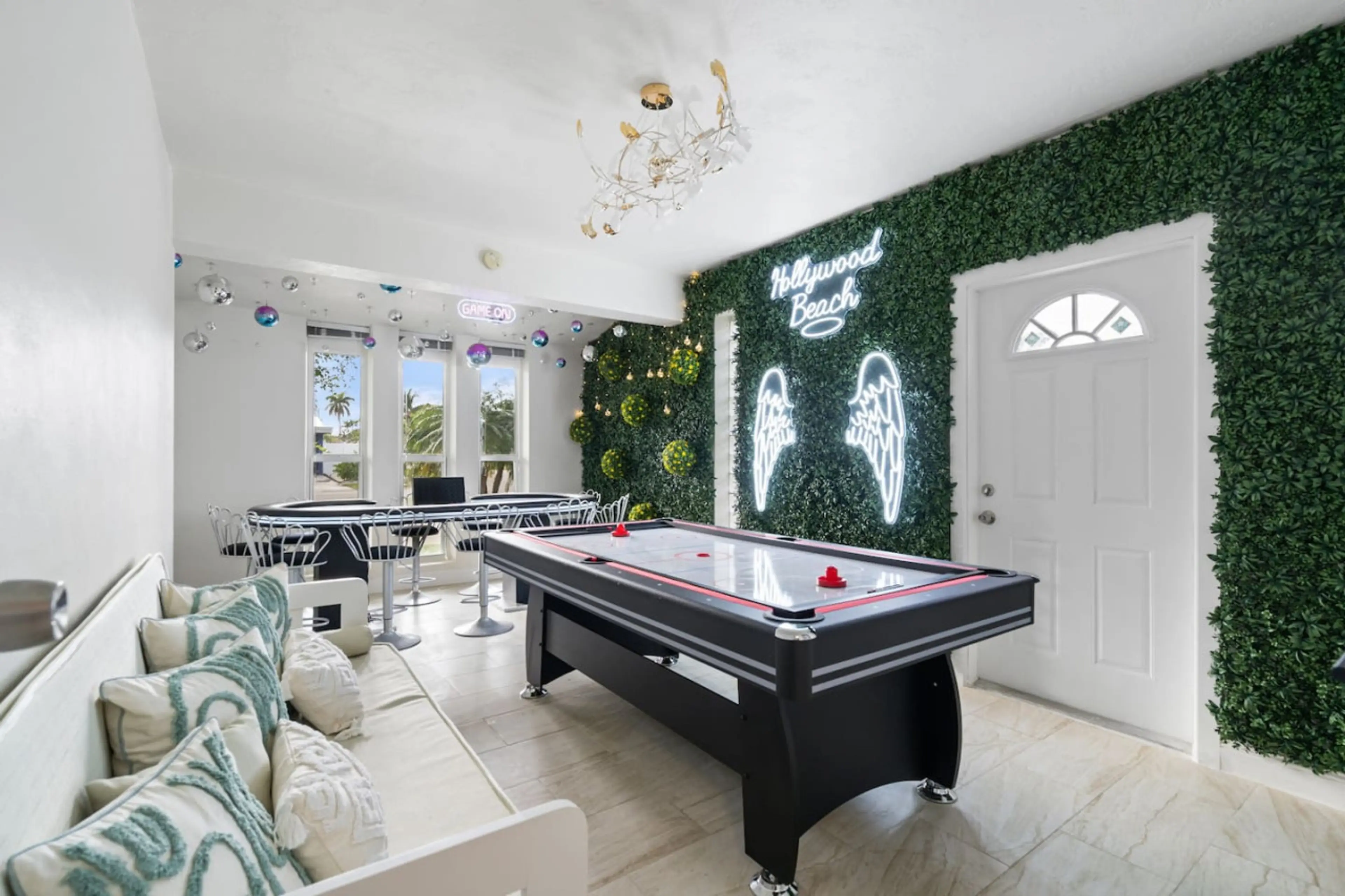 Ultimate game room featuring pool table, air hockey, designer neon wings & living wall. Comfortable seating area. Your entertainment hub
