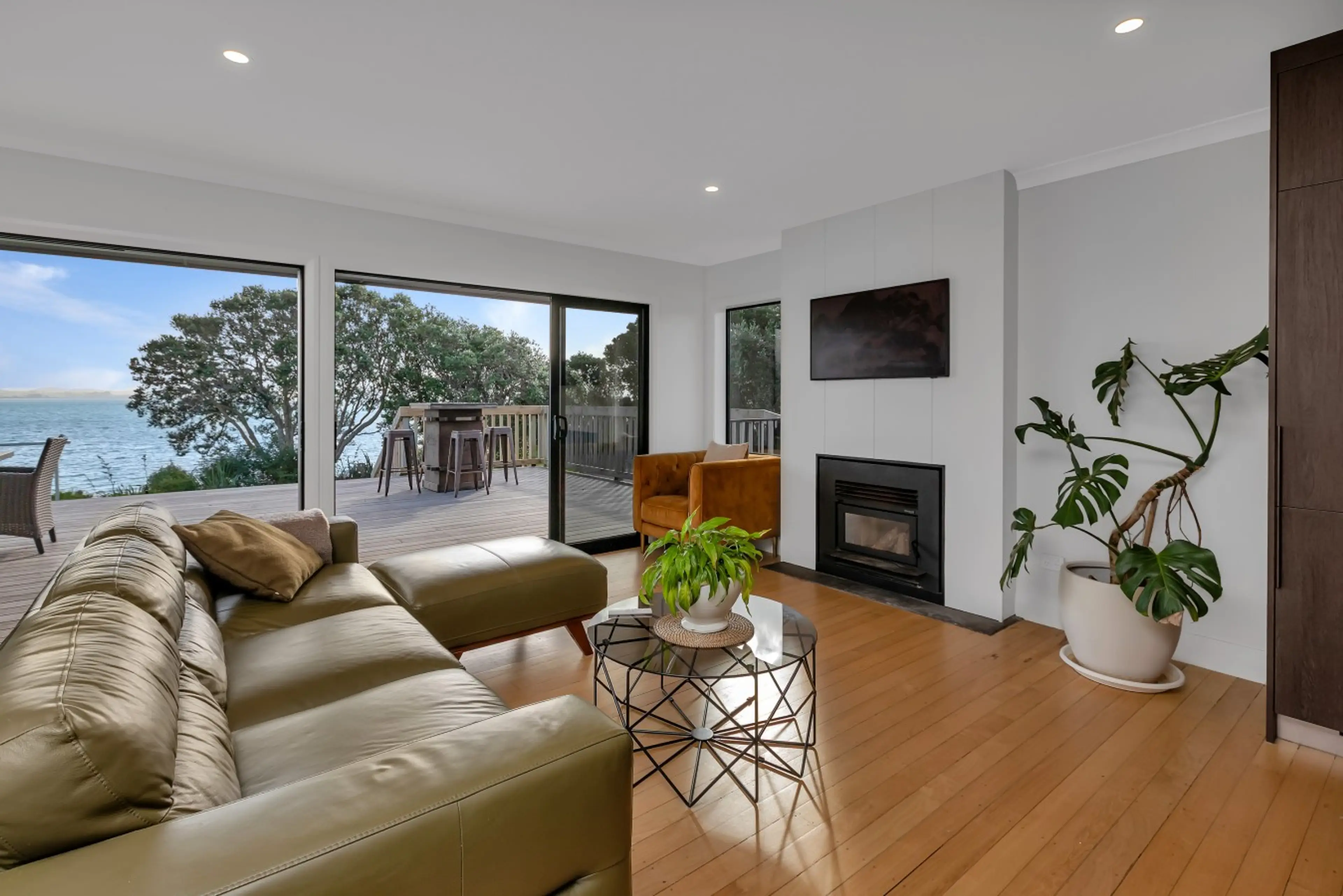Open-plan living room opening onto a large deck with stunning water views. The perfect spot to unwind after a day of exploring.