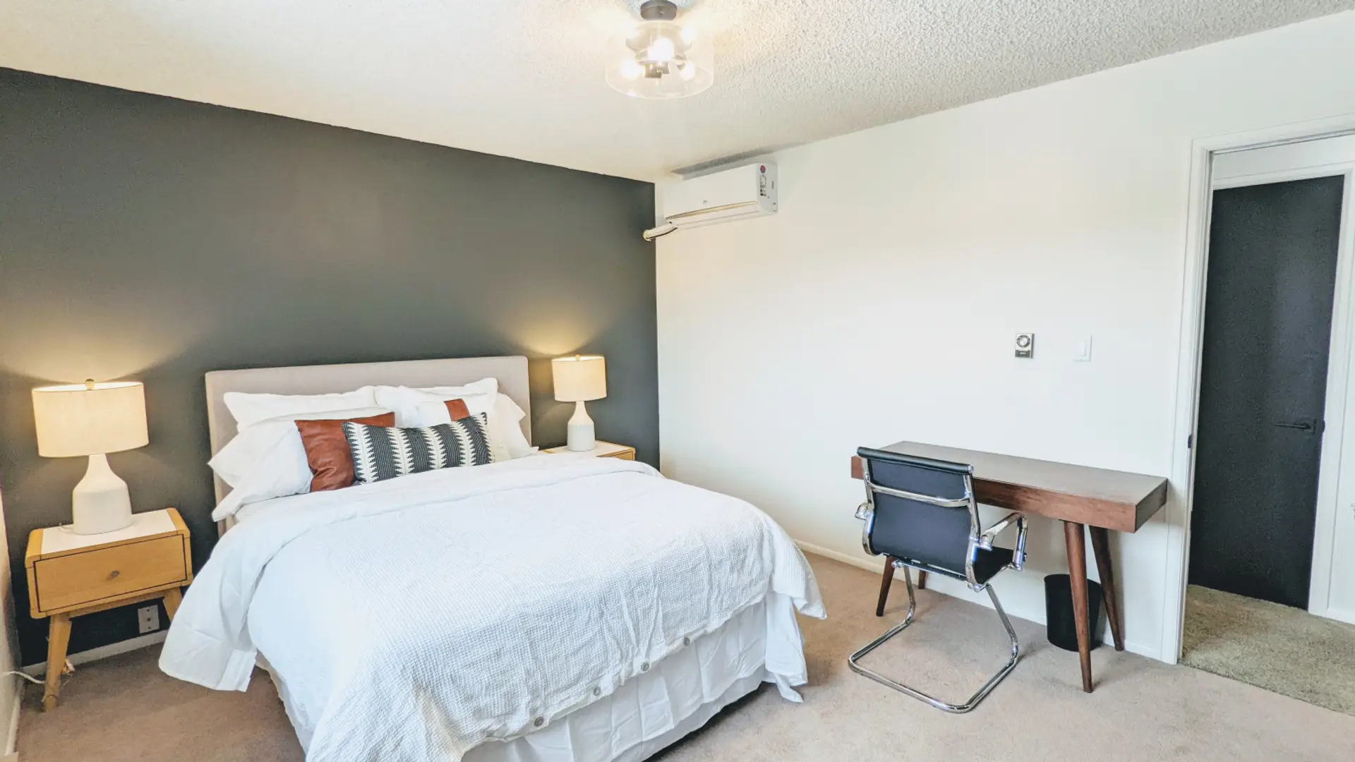 Relax in this private bedroom featuring a comfortable queen-size bed, a dedicated workspace, and a spacious closet for all your storage needs.