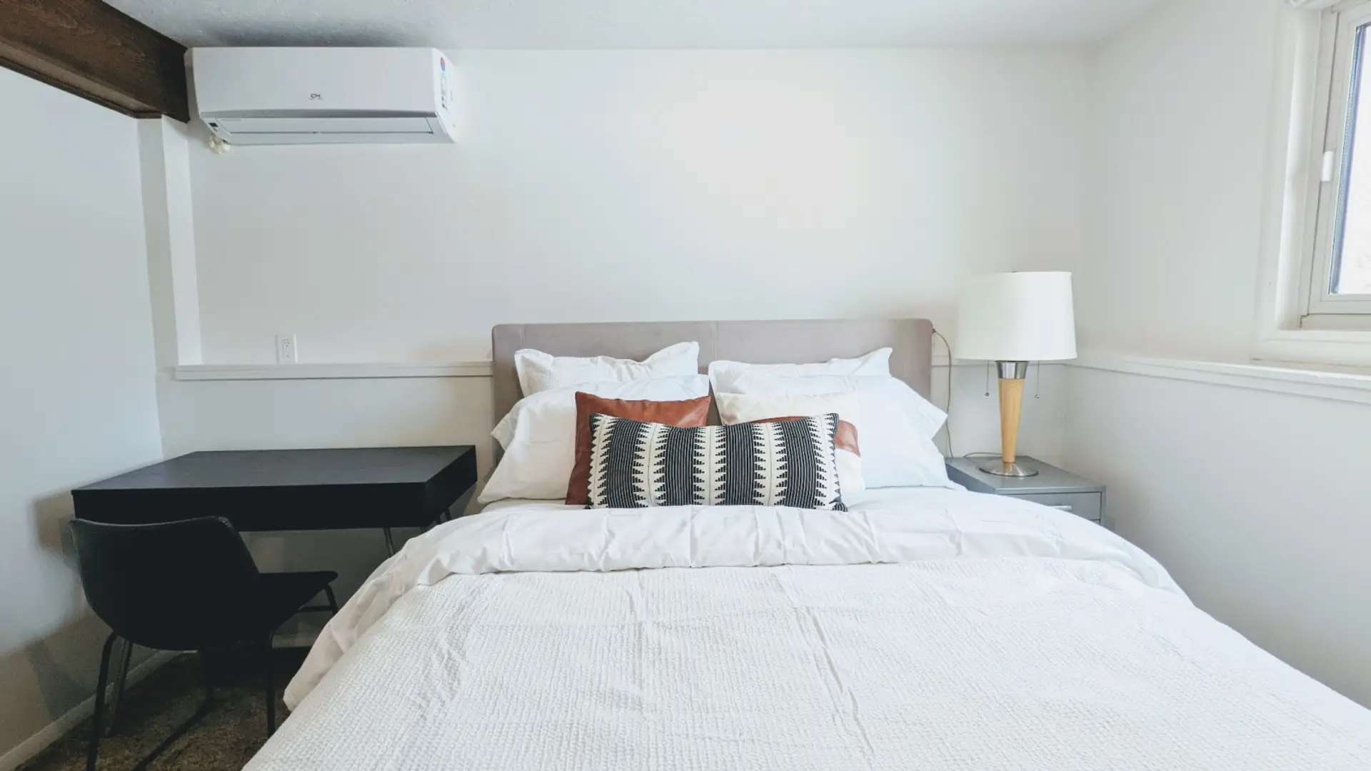 Relax in this private bedroom featuring a comfortable queen-size bed, a dedicated workspace, and a spacious closet for all your storage needs.