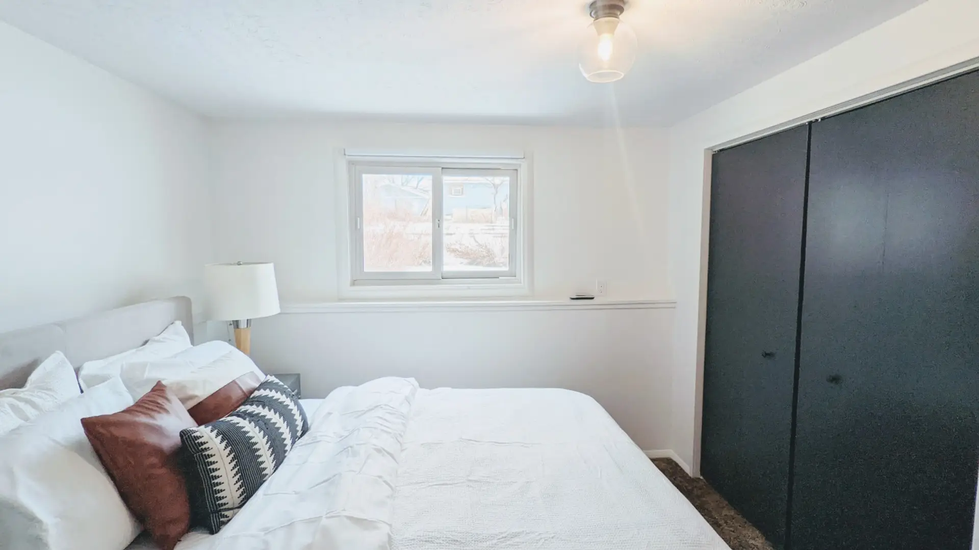 Relax in this private bedroom featuring a comfortable queen-size bed, a dedicated workspace, and a spacious closet for all your storage needs.