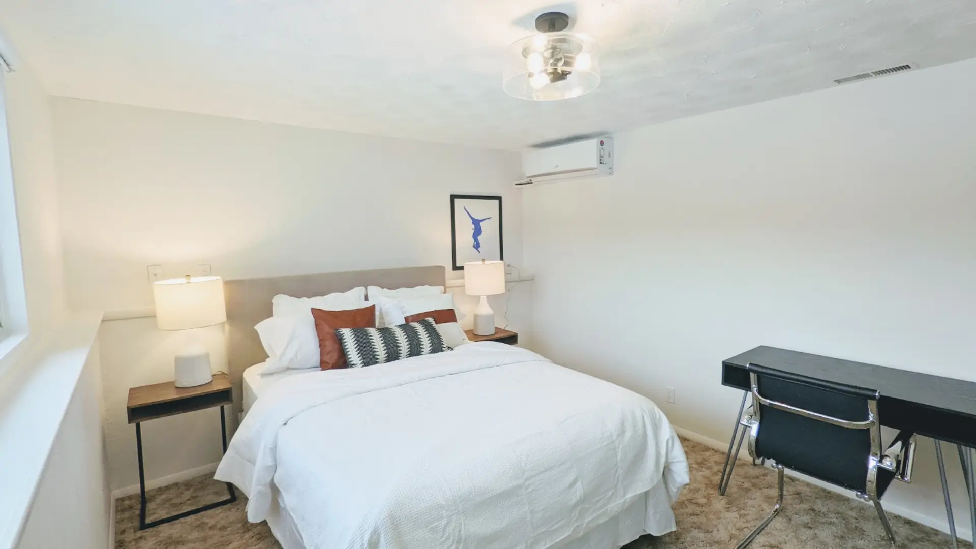 Relax in this private bedroom featuring a comfortable queen-size bed, a dedicated workspace, and a spacious closet for all your storage needs.