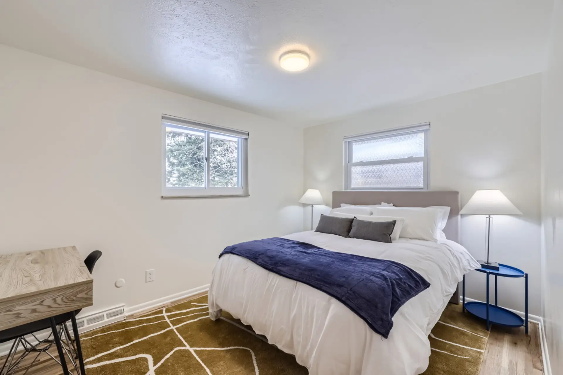 Relax in this private bedroom featuring a comfortable queen-size bed, a dedicated workspace, and a spacious closet for all your storage needs.