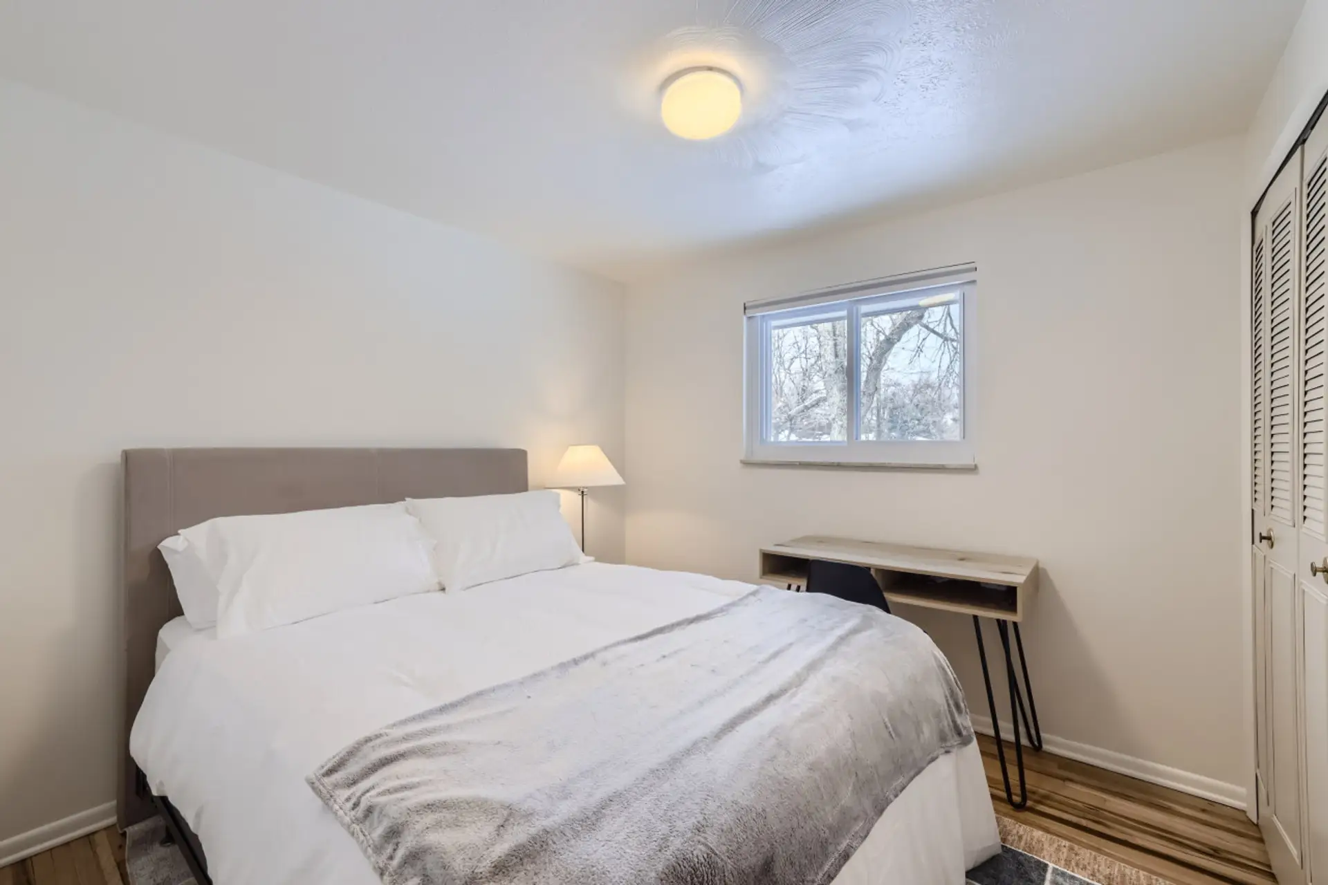 Relax in this private bedroom featuring a comfortable queen-size bed, a dedicated workspace, and a spacious closet for all your storage needs.