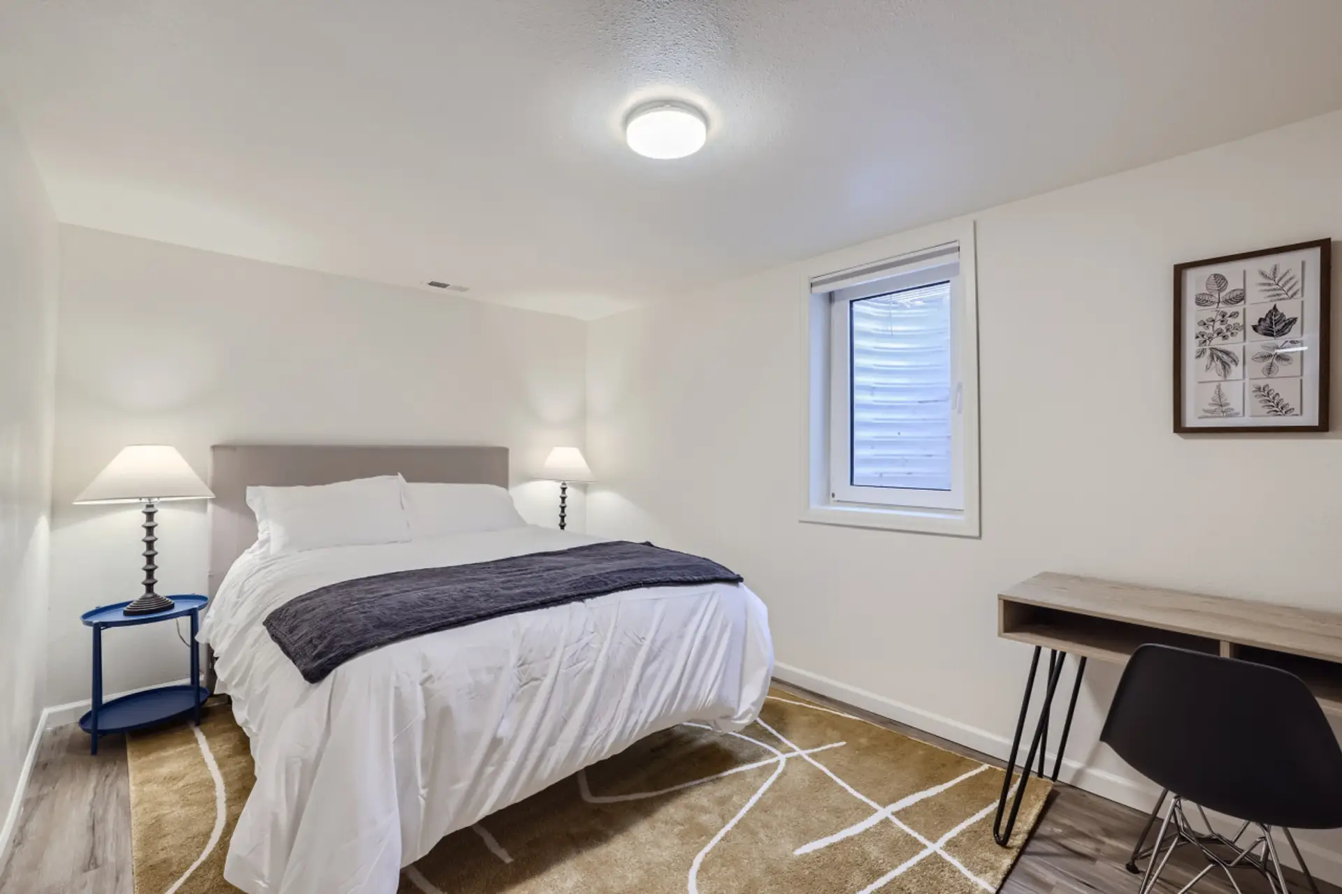 Relax in this private bedroom featuring a comfortable queen-size bed, a dedicated workspace, and a spacious closet for all your storage needs.