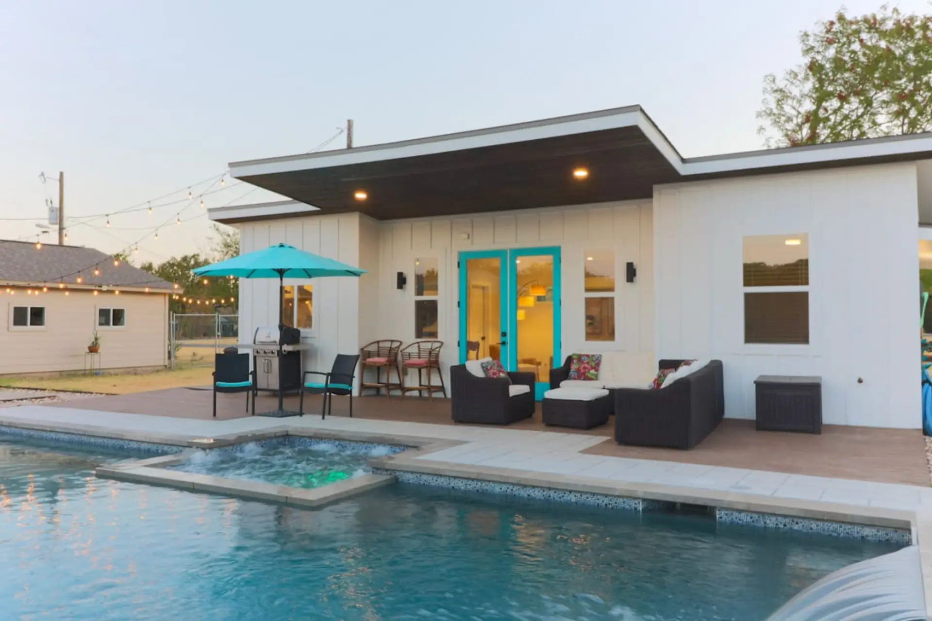 Private backyard casita with bright blue doors, cozy wicker seating, and blackout shades on the windows. Seasonal pool access is available April–November, and the hot tub is NOT  included.