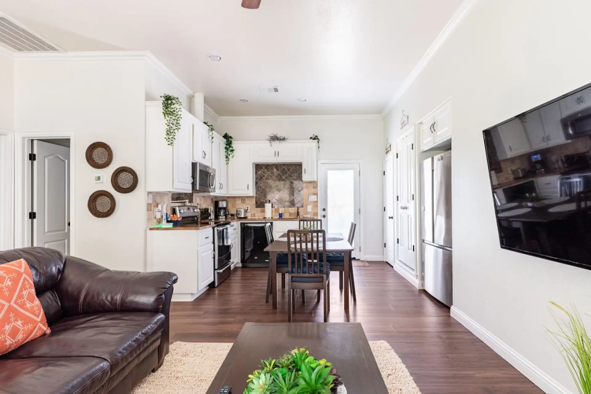 Open living area with leather sofa, 55” Smart TV, and a full kitchen — ideal for a quiet night in.