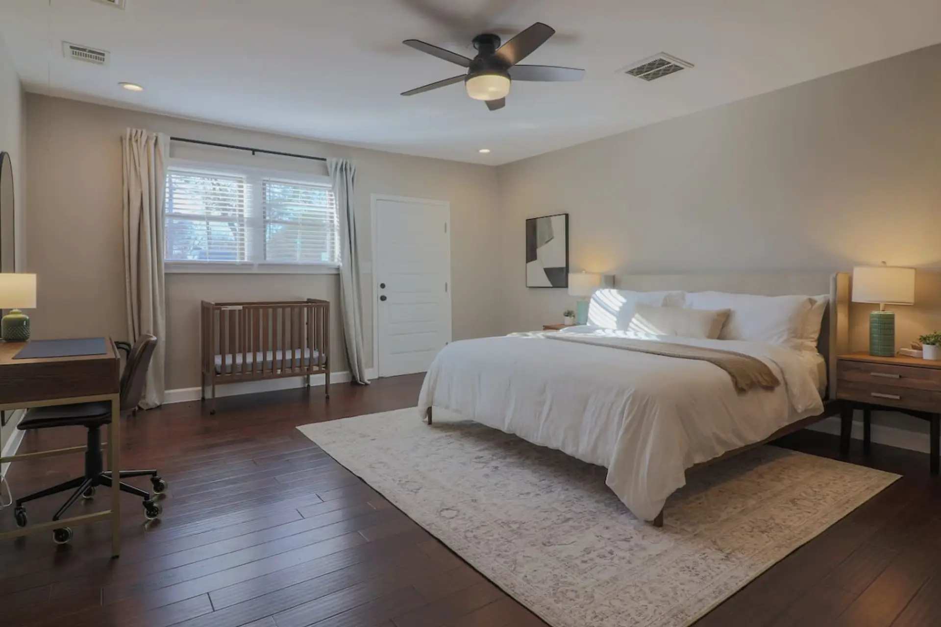 Located separately for added privacy, this king suite includes a dedicated workspace, crib, blackout shades, ceiling fan, and a full-size stacked washer and dryer with complimentary detergent.