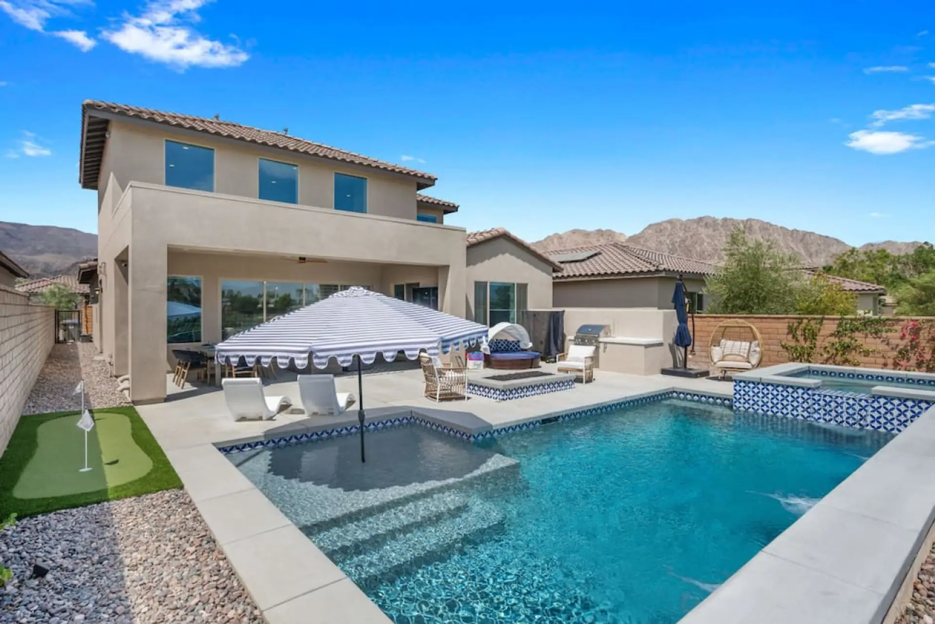 Resort-style backyard w/ pool, spa & shaded patio seating, perfect for sunny days outdoors
