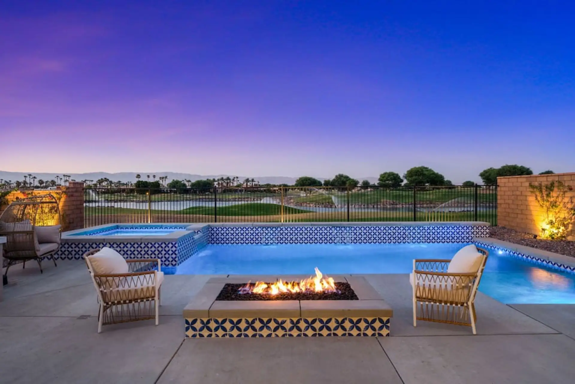 Evening poolside w/ glowing firepit & lounge seating for relaxing nights outdoors