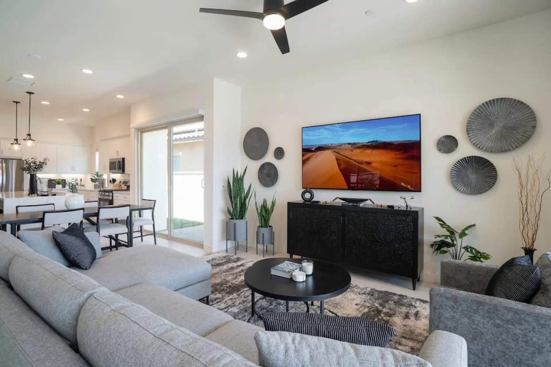 Bright, open living room w/ plush seating, modern fireplace & large TV for cozy nights in
