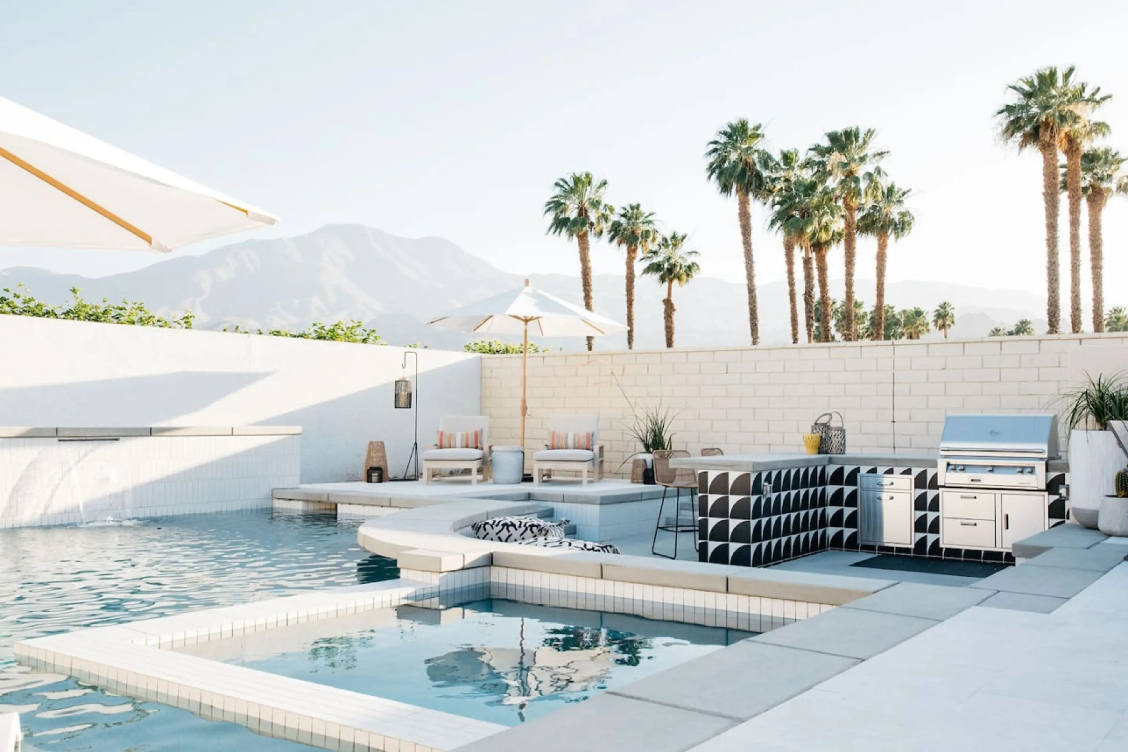 Sunlit pool deck w/ loungers, palms & mountain views for a laid-back day outside