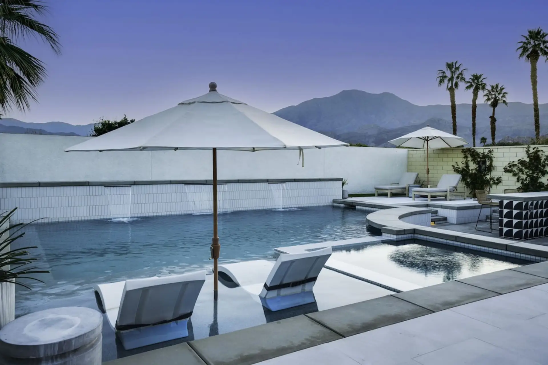 Sparkling pool w/ loungers, umbrella shade & peaceful mountain backdrop