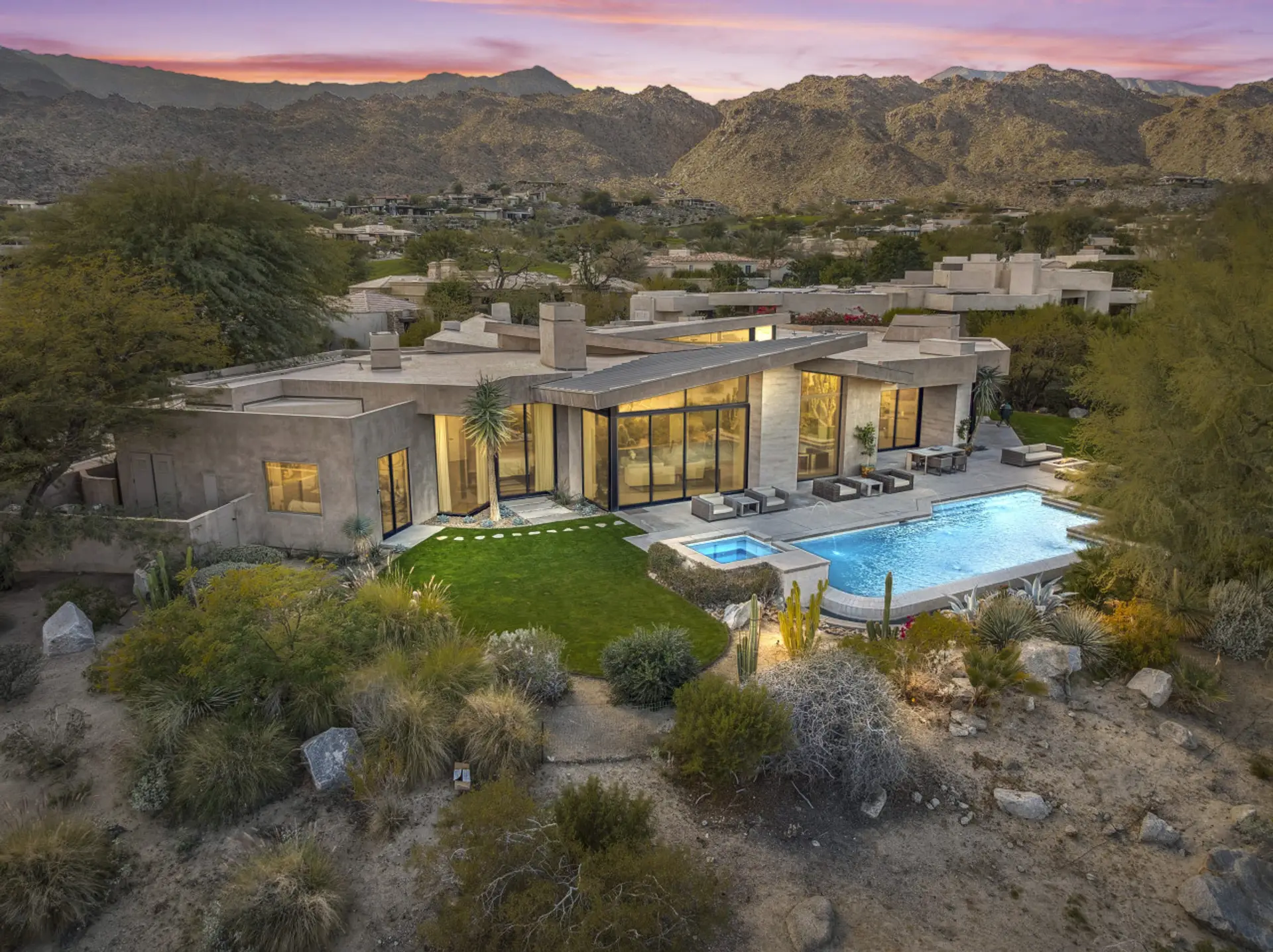 Aerial view of the private estate w/ pool, lawn & modern architecture nestled in nature