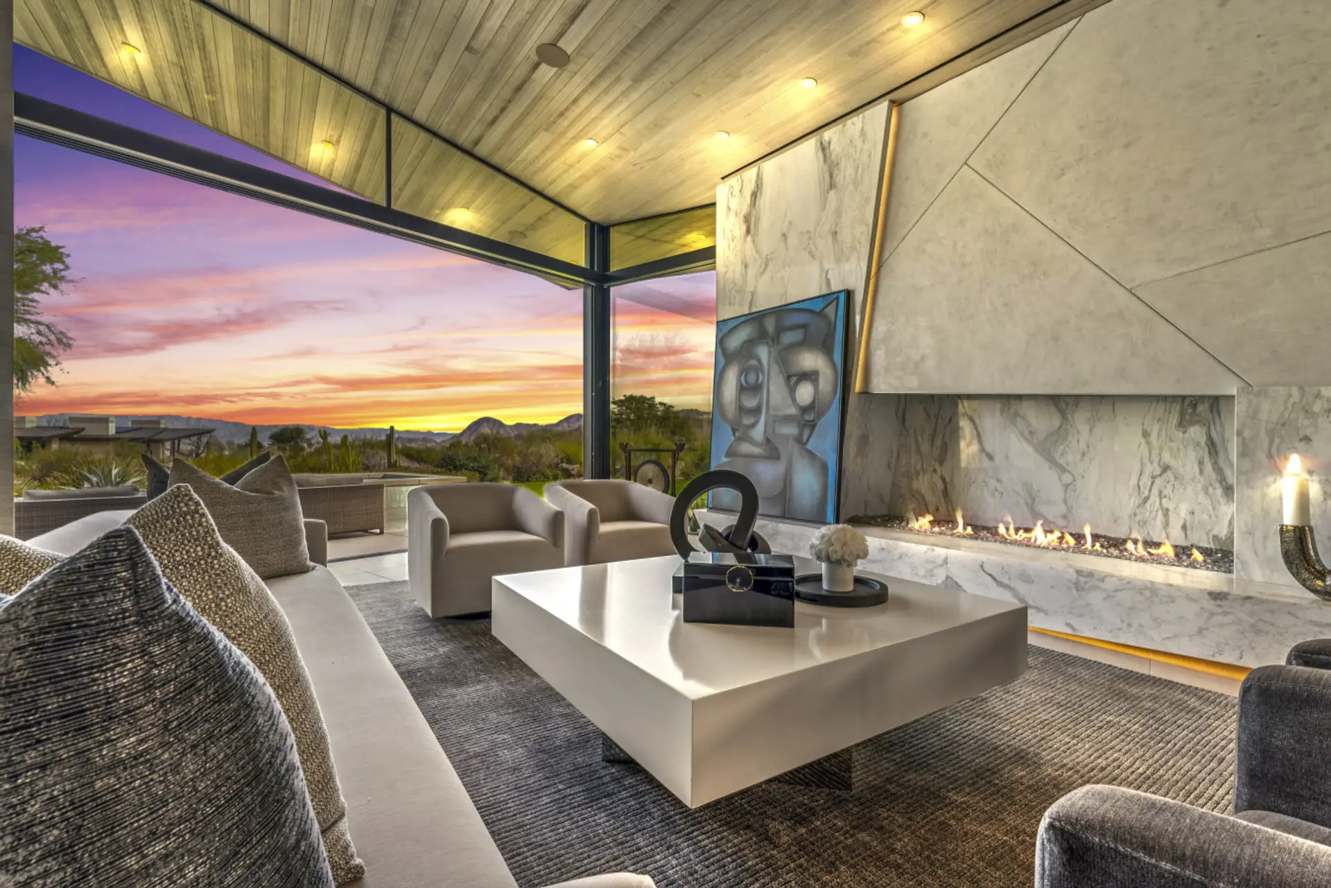 Covered patio lounge w/ fireplace, art accents & sunset views for evening relaxation