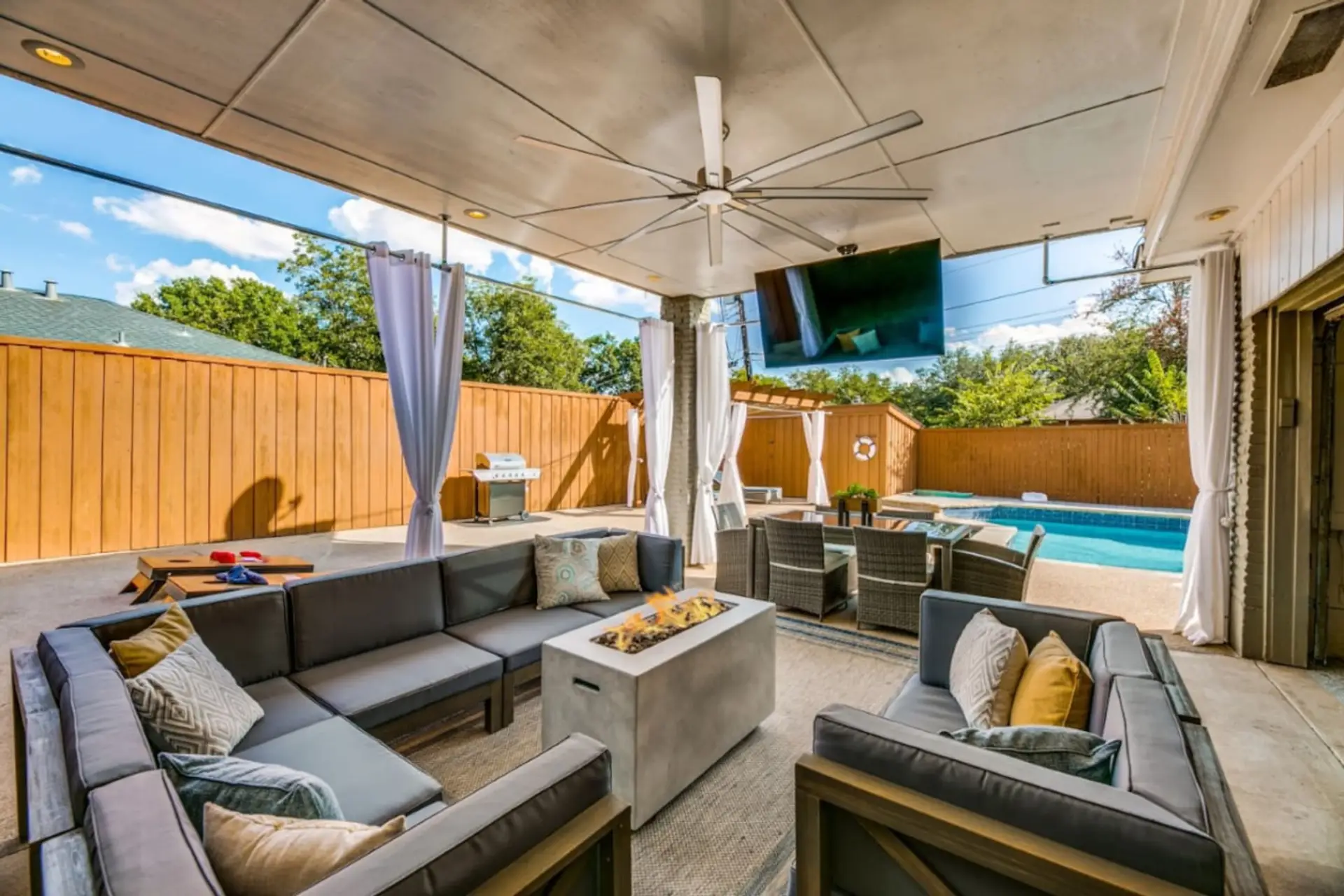 TEXAS SIZED outdoor area with lots of seating, BIG ASS fan, 60" Smart TV that rotates 360 degrees, dinning, BBQ Gas Grill, Fire pit, Hot Tub, Heated Pool and lots of outdoor games
