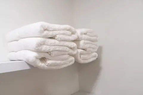Stack of white towels on a shelf