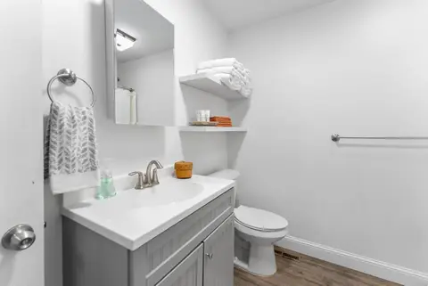 Gray vanity with towels and toiletries on open shelves