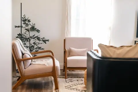 Two armchairs beside a small potted tree in the living room