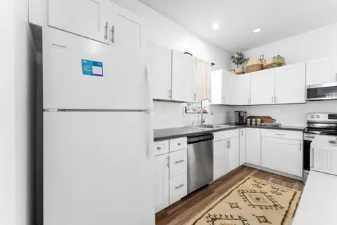 White fridge beside the kitchen counters and range