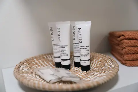 Toiletries in a woven tray beside folded towels