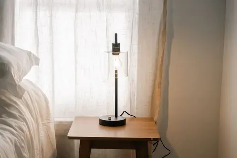 Bedside table with a lamp by the window